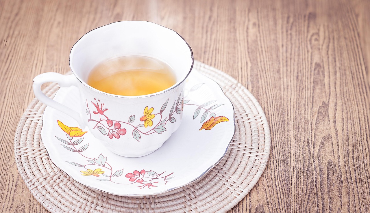 Tazza di tè verde fumante su sfondo naturale, simbolo di accelerazione del metabolismo e perdita di peso.