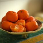 Mandarini freschi su un tavolo, simbolo della loro consumazione serale e dei benefici per la salute.