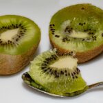 Un kiwi fresco su un tavolo, simbolo dei benefici del consumo serale per il corpo.