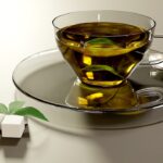 Tazza di tè verde fumante su un tavolo, simbolo di benessere e metabolismo attivo.